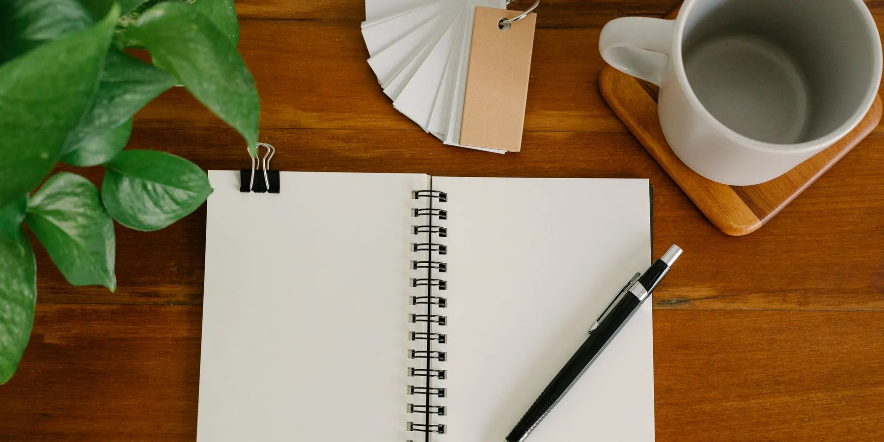 Ahşap masa üzerinde defter, kupa ve kalem gibi promosyon ürünleri